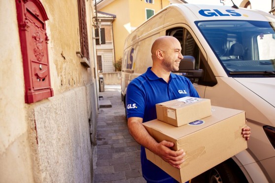 A happy driver with parcels on his hands in the street