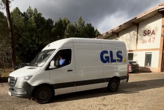 A GLS delivery van parked in front of the SPA 47 shelter during a solidarity tour with Ultra Premium Direct to support abandoned animals.