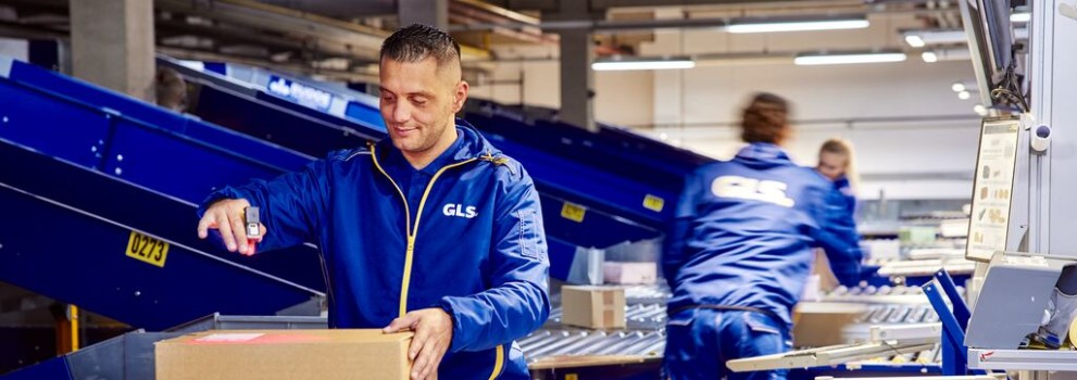 Employees sort and scan parcels on a conveyor belt
